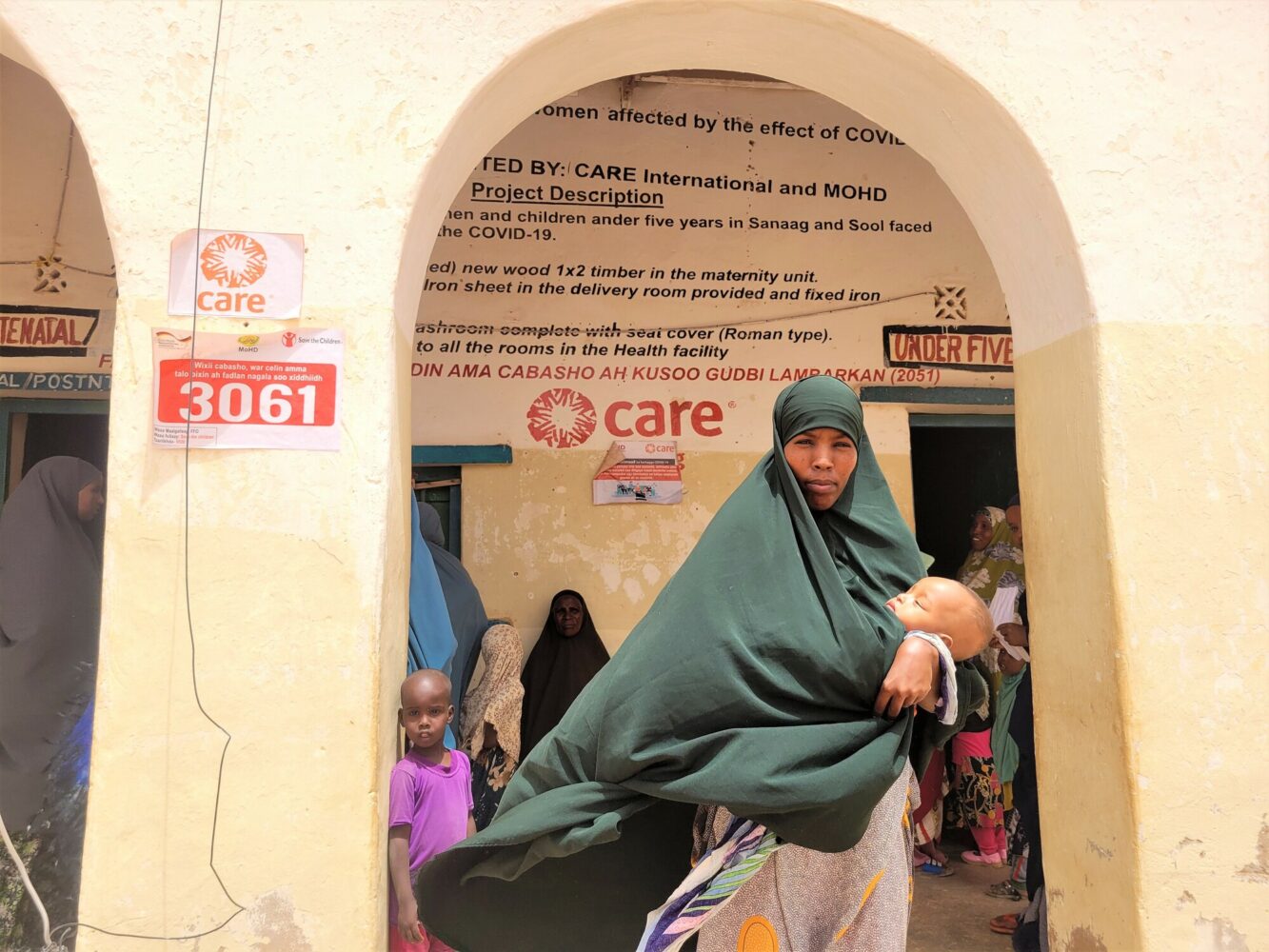 Une femme et son bébé devant un centre de santé soutenu par l'ONG CARE en Somalie