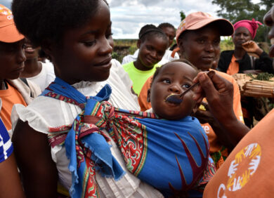 Une humanitaire nourrit un enfant touché par la malnutrition en Afrique