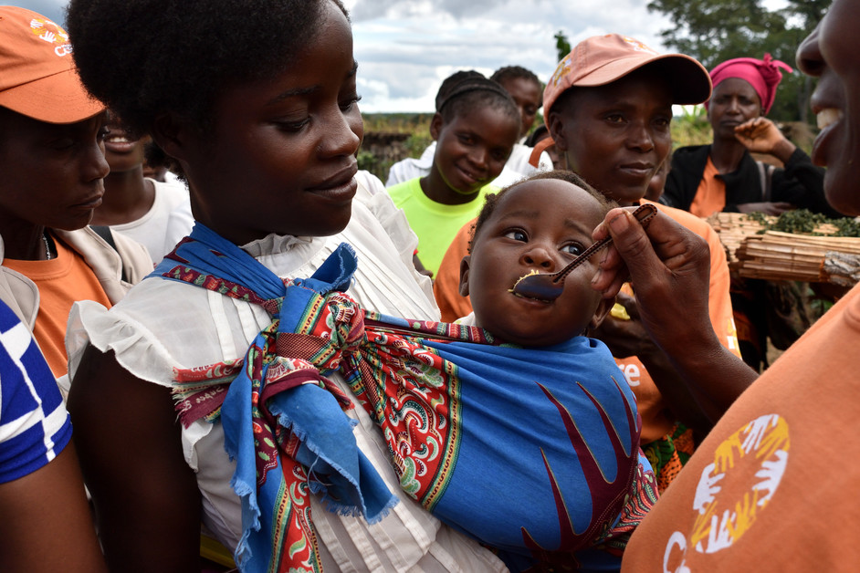 Une humanitaire nourrit un enfant touché par la malnutrition en Afrique