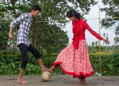 Un garçon et une fille jouent au football au Bangladesh