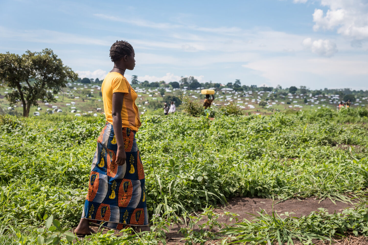 Une femme marche dans un champ en Afrique