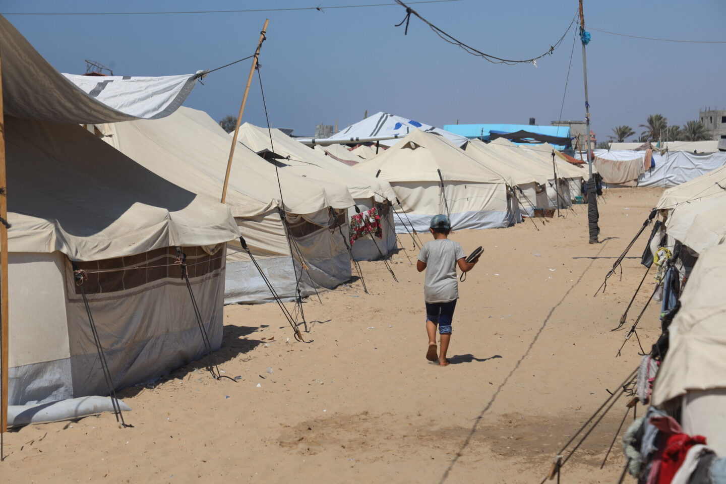 Un enfant marche dans un camp de déplacés par la guerre à Gaza