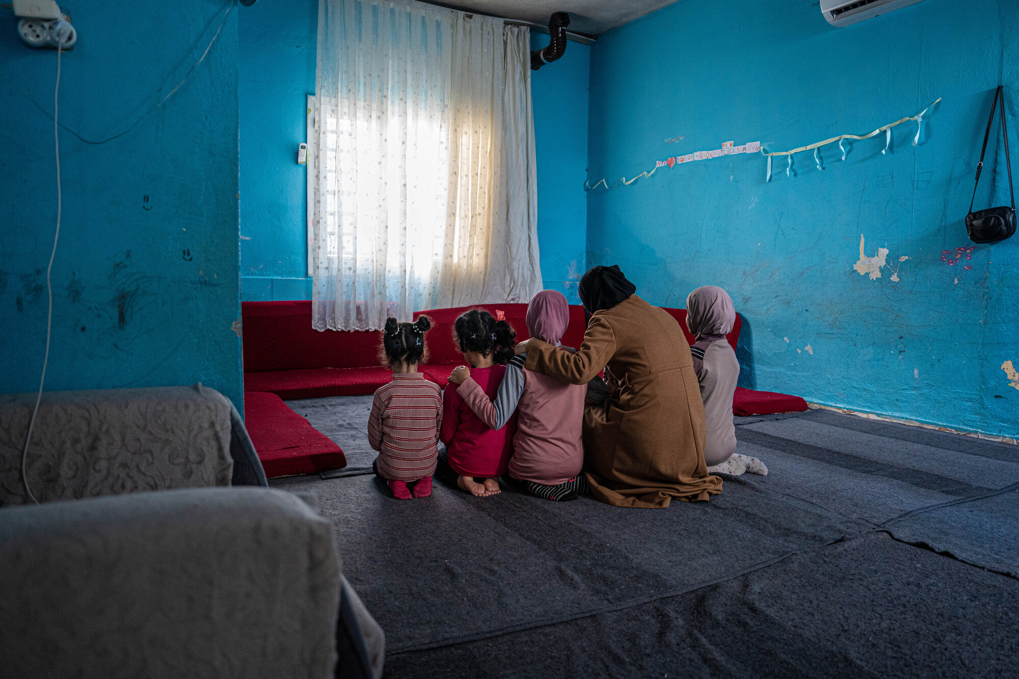 Une famille se prend dans les bras dans sa maison en Turquie, deux ans après les tremblements de terre de 2023