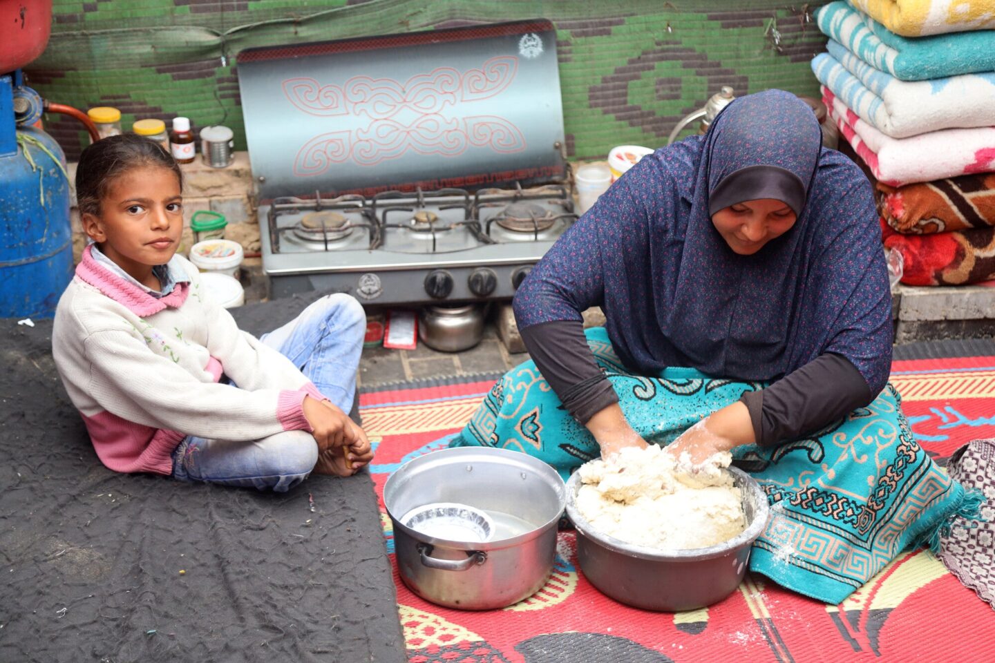 Une femme réfugiée cuisine dans une tente à Gaza