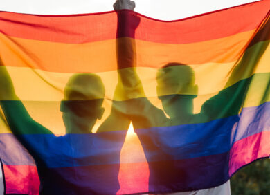 Deux personnes tiennent le drapeau des fiertés